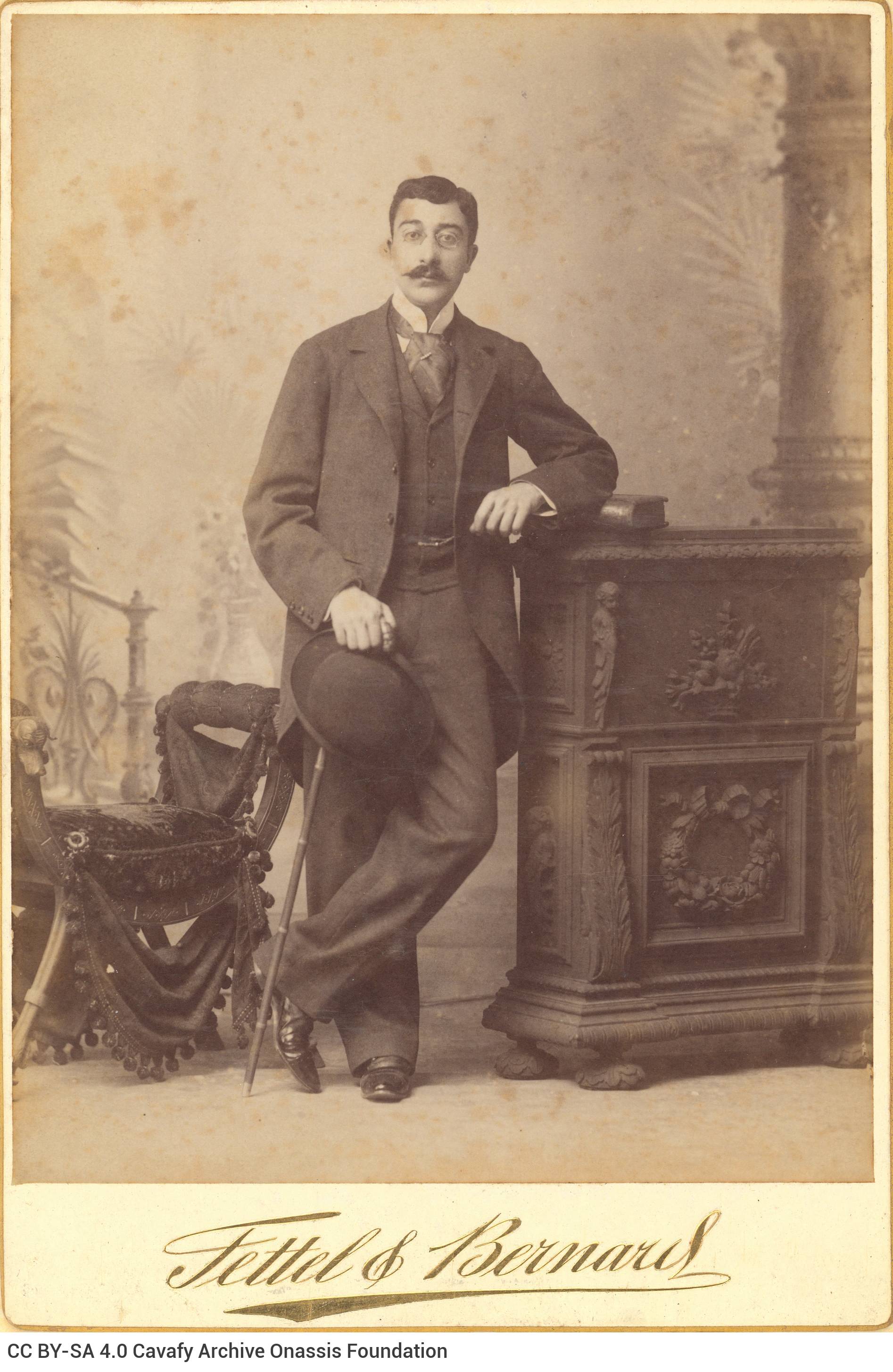 Undated photographic portrait of Cavafy by the photo shop of Fettel & Bernard in Alexandria. The poet has a mustache, he wear