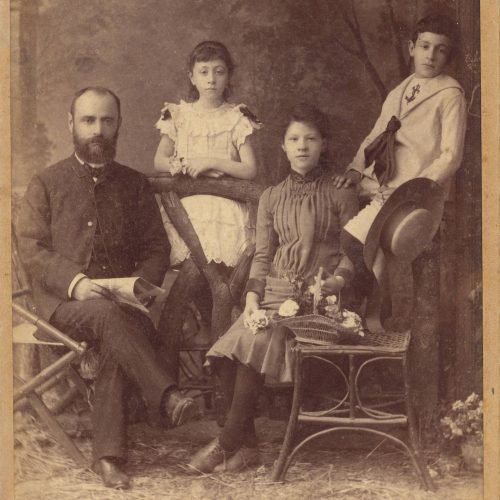 Photograph of a man, sitting in a chair, with two girls and a boy, from the Abdullah Frères photo shop of Istanbul. The logo