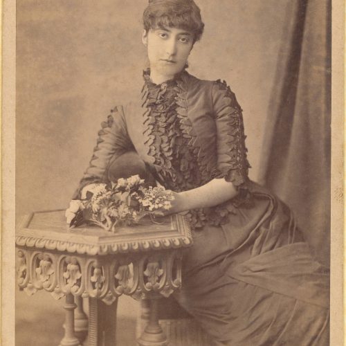 Φωτογραφικό πορτρέτο καθιστής γυναίκας που ακουμπάει τα χέρια της σ
