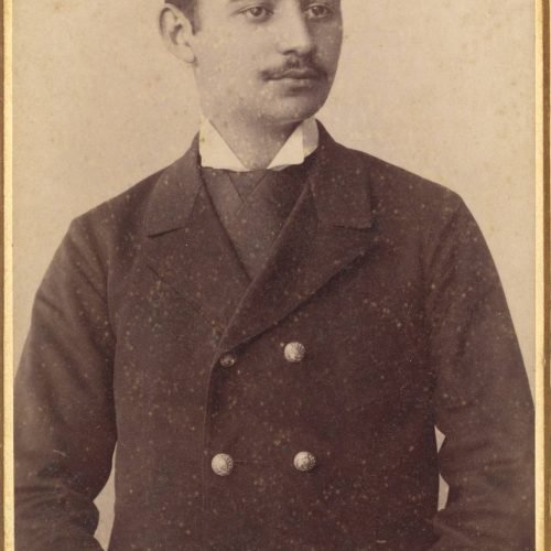 Photographic portrait of a young man in a moustache, wearing a military-type overcoat. Handwritten dedication to his aunt, Ch