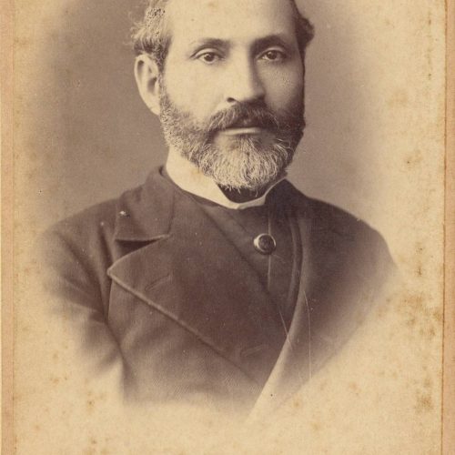 Photographic portrait of a man in a suit, with a beard. The logo of the photo shop in the lower part of the recto as well as 