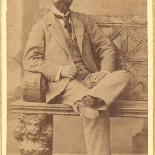 Φωτογραφία του Παύλου Καβάφη καθισμένου, με μουστάκι και γενειάδα. Ο