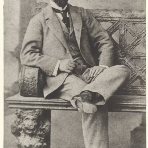 Photograph of Paul Cavafy seated, with a moustache and a beard. The logo of the photo shop in the lower part of the recto as 