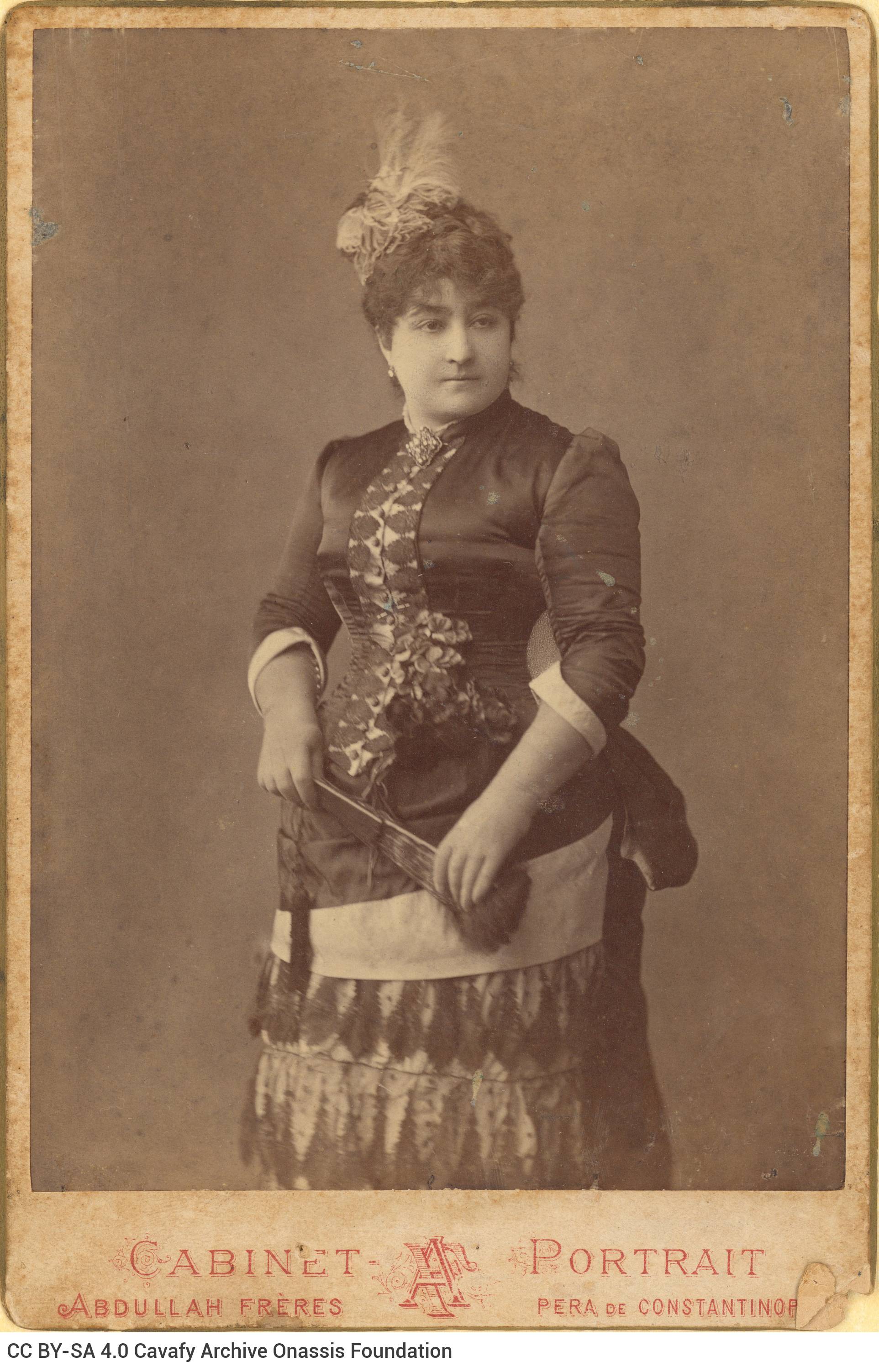Photograph of Charikleia Cavafy in Istanbul (1882-1885). She is wearing a long dress with embroidery and lace and is holding 