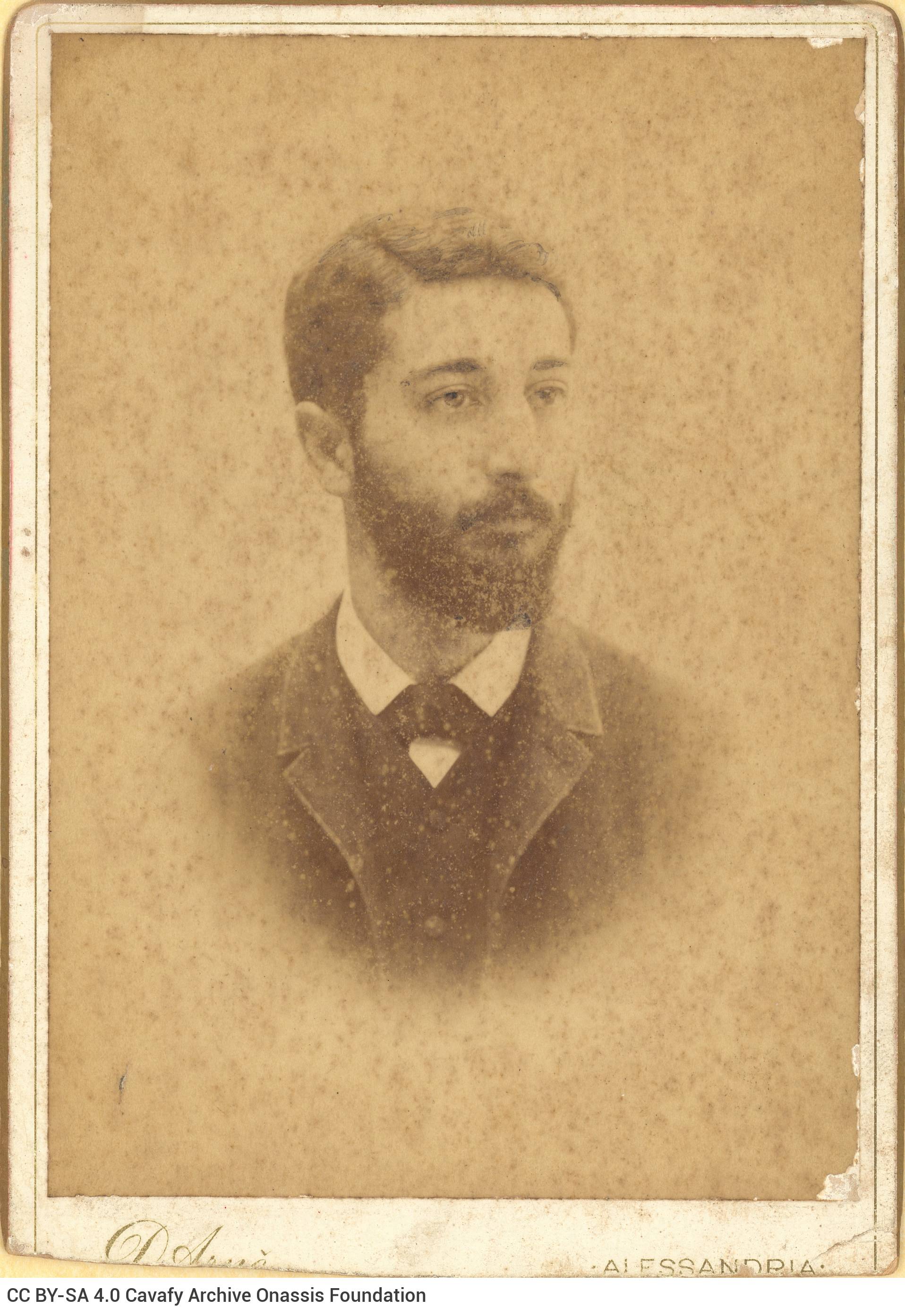 Photographic portrait of a young man with a moustache and a beard. The logo of the photographer in the lower part of the rect