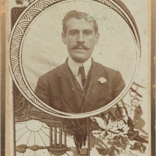 Photographic portrait of a young man with a moustache, wearing a suit. In the lower part of the recto, the printed indication