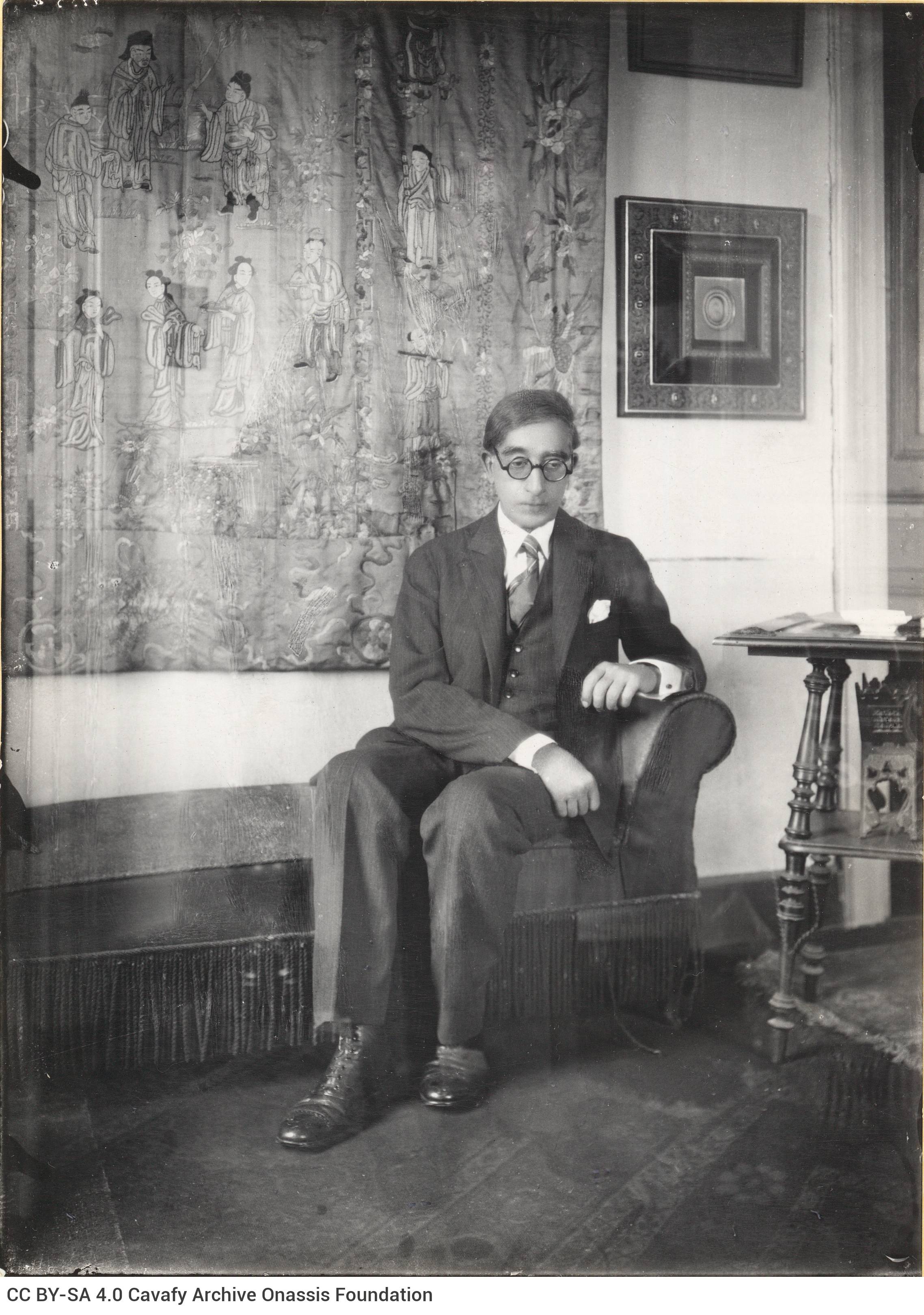 Copy of a photograph of Cavafy in his apartment. He is depicted sitting in a sofa, in his parlour. The original photograph wa