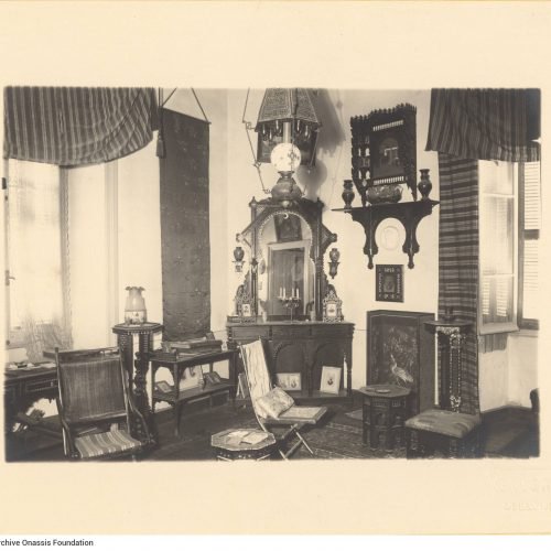 View of the interior of Cavafy's flat. It depicts the living room, with chairs, a desk and a console table with a mirror. The