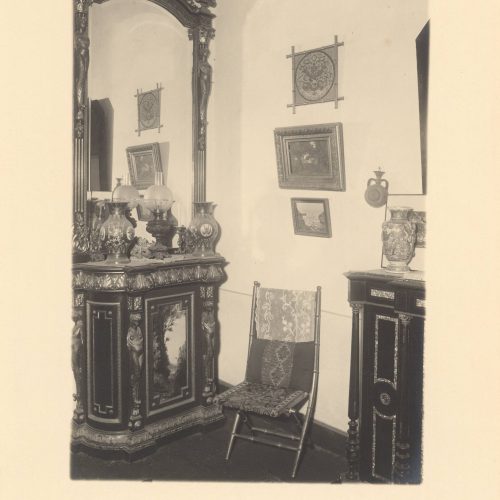 Photograph of the interior of Cavafy's flat. View of the living room, with a console table and a mirror, a seat and frames on